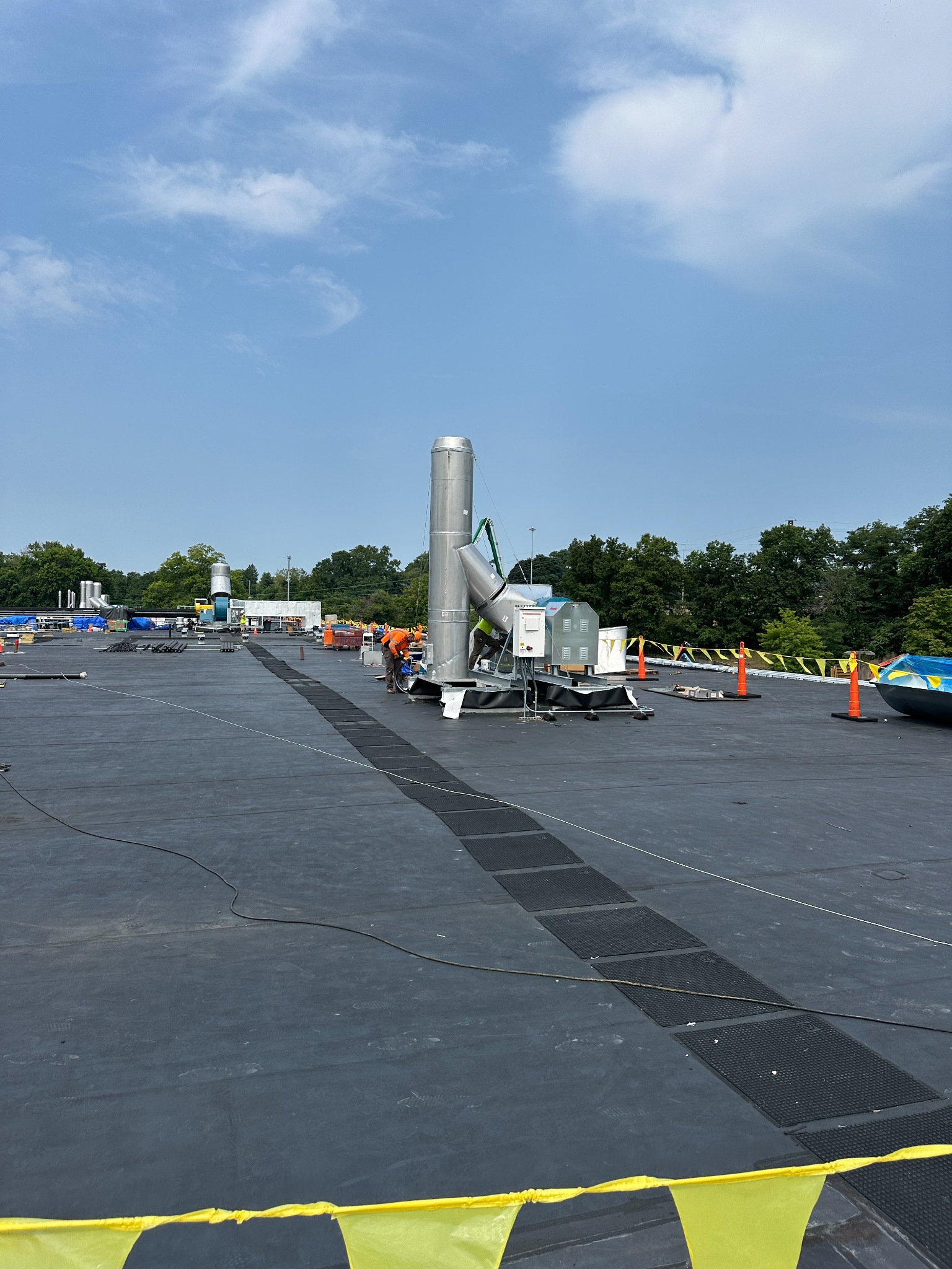 Rooftop crew setting up large exhaust system